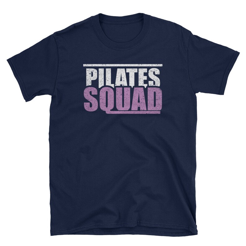 May include: Navy blue t-shirt with a white and pink distressed graphic that says "PILATES SQUAD".