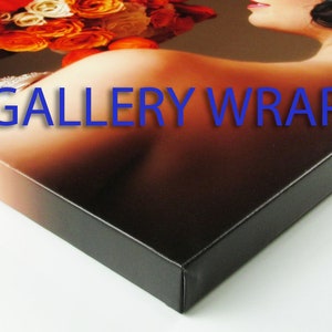 K&ouml;nnte beinhalten: Nahaufnahme eines Leinwanddrucks, der um einen Holzrahmen gewickelt ist. Das Bild zeigt eine Frau, die einen Strau&szlig; orangefarbener und wei&szlig;er Blumen h&auml;lt. Der Text "GALLERY WRAP" ist auf die Leinwand gedruckt.