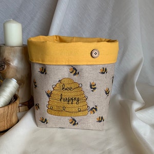 Fabric storage box made from  bee design fabric and embroidered beehive with bee happy script. Lined with yellow cotton