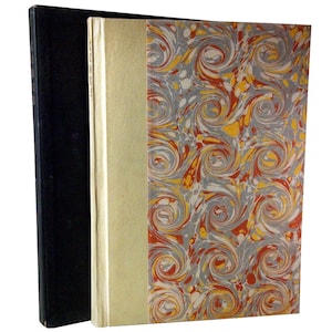 May include: A book with a marbled cover in shades of gray, red, and yellow. The book is bound in a black cover.