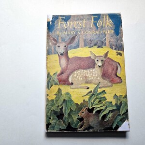 Könnte beinhalten: Vintage-Buch mit dem Titel "Forest Folk" von Mary & Conrad Buff. Das Cover zeigt Illustrationen von Hirschen, einem Bären und einem Eichhörnchen in einer Waldszene. Das Buch weist Gebrauchsspuren auf.