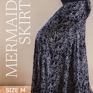 May include: Navy blue mermaid skirt with a white floral pattern. The skirt has a wide, dark blue waistband and flares out from the knees. The text "MERMAID SKIRT" is printed vertically on the left side, and "SIZE M" is printed at the bottom.