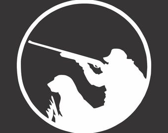 May include: White silhouette of a hunter aiming a rifle, accompanied by a dog, set within a white circular frame against a dark gray background. The image depicts a hunting scene.
