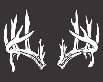 May include: A pair of white deer antlers with a detailed, intricate design. The antlers are symmetrical and have multiple points.