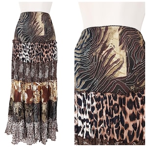 May include: A long, tiered skirt with a patchwork design featuring animal prints and abstract patterns in shades of brown, black, and beige. The skirt has a ruffled hem and a black lace trim.