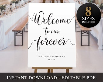May include: A white wedding welcome sign with black calligraphy that reads "Welcome to our forever" with the couple's names and wedding date below. The sign is on an easel and there are chairs in the background.