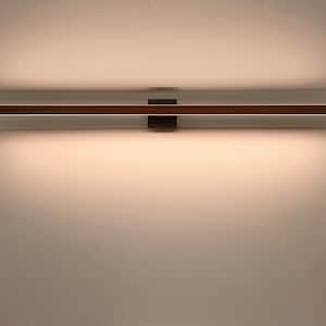 May include: A modern, rectangular wall-mounted light fixture. The fixture has a long, thin, brown wooden frame with a bright, linear light source. The light is mounted on a dark square base against a white wall.