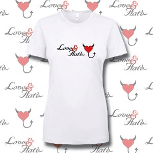 Puede incluir: Camiseta blanca con un corazón rojo con cuernos de diablo y una cola. El texto "Love & Hate" está impreso en la camiseta.