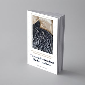 May include: A white book with a blue and gold design. The book is titled "The Complete Weighted Blanket Handbook" and features a photo of a weighted blanket on a bed. The book is by Jason Christensen.