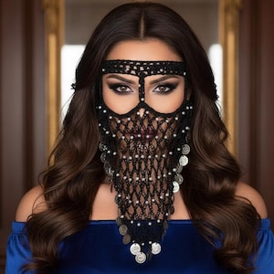 May include: A black crocheted face veil with silver coin accents and white bead embellishments. The veil is worn with a matching headband. The person is wearing a blue off-the-shoulder top.