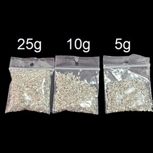 Może przedstawiać: Trzy przezroczyste plastikowe torebki z srebrnym brokatem w środku. Torebki są oznaczone 25g, 10g i 5g.