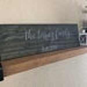 May include: A rustic wooden sign with the word "remarkable" written in white chalk.