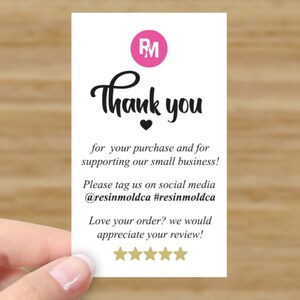 Pu&ograve; includere: Un biglietto da visita bianco con la scritta "Thank you" in corsivo nero, un logo rosa e un cuore. La carta include anche testo sul supporto alle piccole imprese e sui social media.
