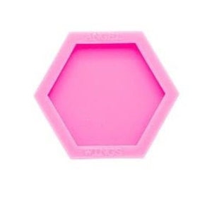May include: Pink silicone mould shaped like a hexagon. The mould is designed to create a hexagonal coaster or other craft project.