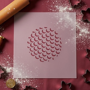 May include: A pink stencil featuring a circular design of crescent shapes, with a wooden rolling pin, star-shaped cookie cutters, and flour scattered on a red surface. A gold seal is also present.