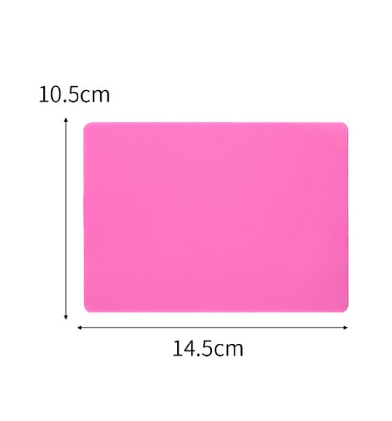 K&ouml;nnte beinhalten: Eine rosa Silikon-Backmatte mit den Ma&szlig;en 10,5 cm x 14,5 cm.
