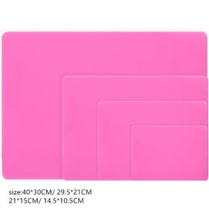 K&ouml;nnte beinhalten: Vier rosa Silikon-Backmatten in verschiedenen Gr&ouml;&szlig;en. Die Matten sind 40x30cm, 29,5x21cm, 21x15cm und 14,5x10,5cm gro&szlig;.