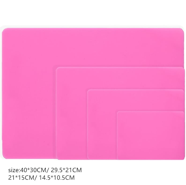 K&ouml;nnte beinhalten: Vier rosa Silikon-Backmatten in verschiedenen Gr&ouml;&szlig;en. Die Matten sind 40x30cm, 29,5x21cm, 21x15cm und 14,5x10,5cm gro&szlig;.