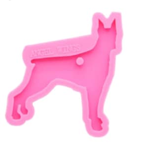 May include: Pink silicone mould shaped like a standing dog. The mould has the words "Angel Wings" embossed on the side.