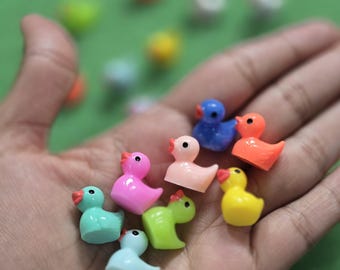 May include: A collection of colorful rubber duck figurines in various poses. The ducks are made of a soft, pliable rubber and are perfect for bath time or as a decorative accent.