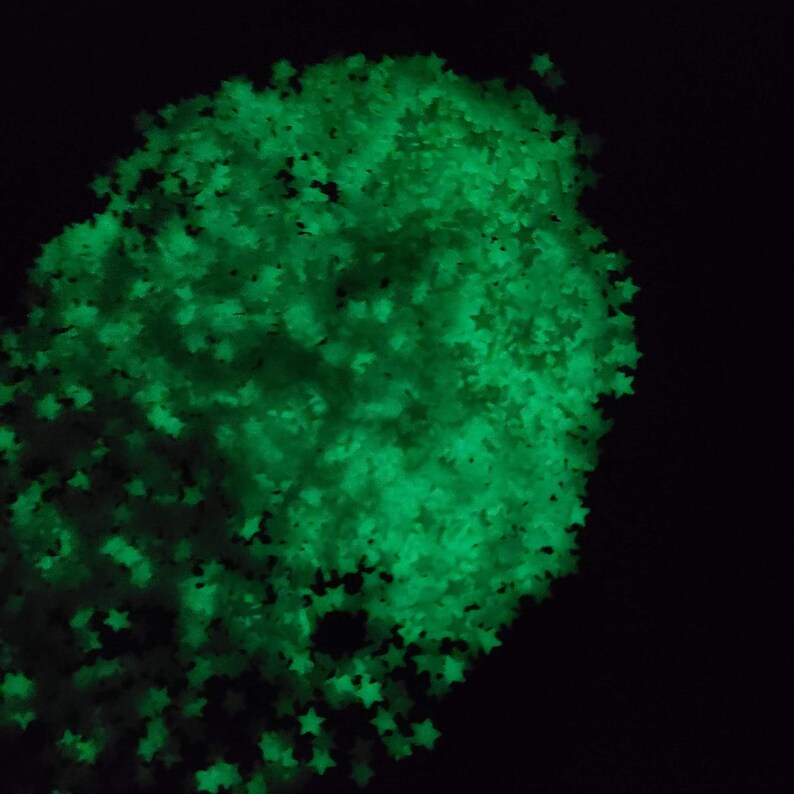 May include: A cluster of glowing green star-shaped confetti against a black background. The stars are densely packed, creating a bright, luminous effect. Ideal for crafts, decorations, or adding a touch of sparkle.