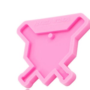May include: Pink silicone mold shaped like a baseball diamond with two crossed baseball bats. The mold has the text "Angel Wings" on the top.