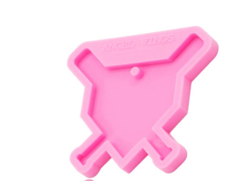 May include: Pink silicone mold shaped like a baseball diamond with two crossed baseball bats. The mold has the text "Angel Wings" on the top.