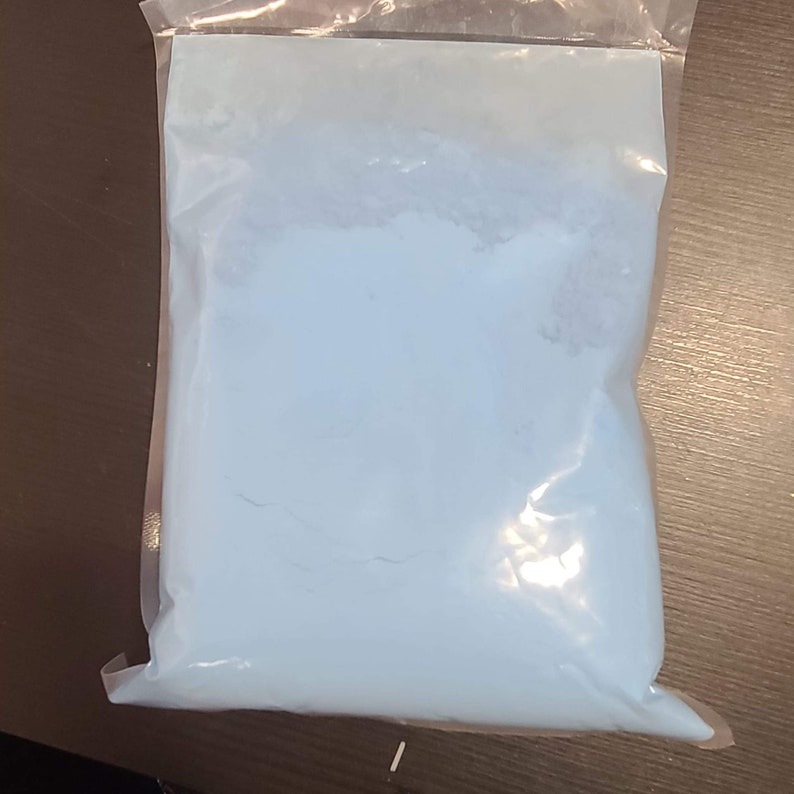 May include: A resealable plastic bag filled with light blue powder.