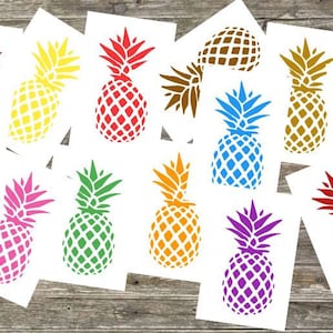 Op de afbeelding: Twaalf verschillende gekleurde ananassilhouetontwerpen op witte kaarten. De ananas zijn in verschillende kleuren, waaronder rood, oranje, geel, groen, blauw, paars en bruin.