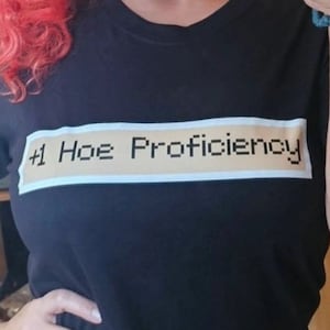Puede incluir: Camiseta negra con un rectángulo blanco y el texto "#1 Hoe Proficiency" impreso en ella.