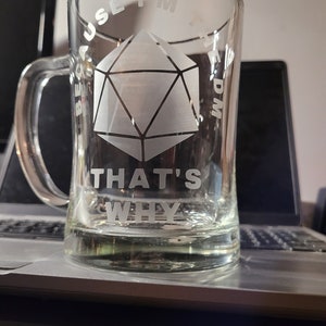 May include: A clear glass mug with a white etched design. The design features a 20-sided die, the words "Because I'm the DM that's why".