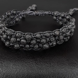 以下が含まれることがあります： 黒曜石ビーズと結び目のコードで作られた黒いブレスレット