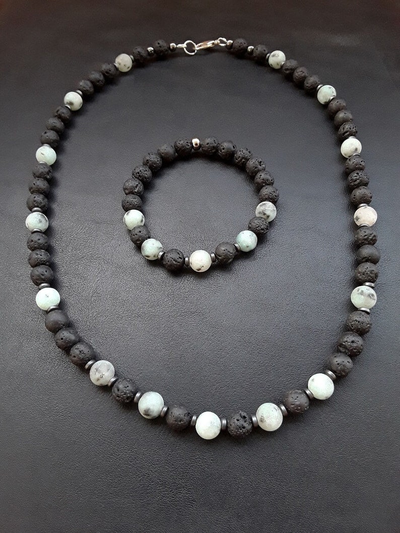 May include: A set of black lava rock and green gemstone beads, one necklace and one bracelet. The necklace has a silver clasp.