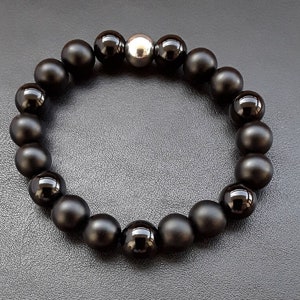 May include: A black onyx beaded bracelet with a silver bead accent.