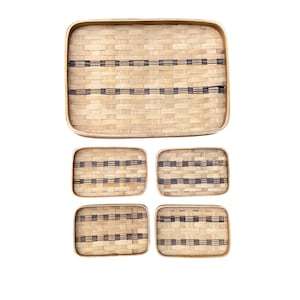 May include: Set of five woven bamboo trays with black stripes. The largest tray is rectangular and the four smaller trays are square.