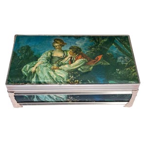 Joyero musical vintage Schmid Bros. de tela de seda. "La carta de amor" de Jean-Honoré Fragonard reproduce "Gotas de lluvia siguen cayendo sobre mi cabeza", década de 1960.