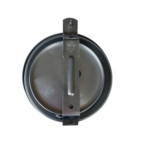 May include: A round, silver-colored metal object with a black rim and a silver bracket. The bracket has a decorative emblem and is attached to the top of the object. The object appears to be a lid or cover.