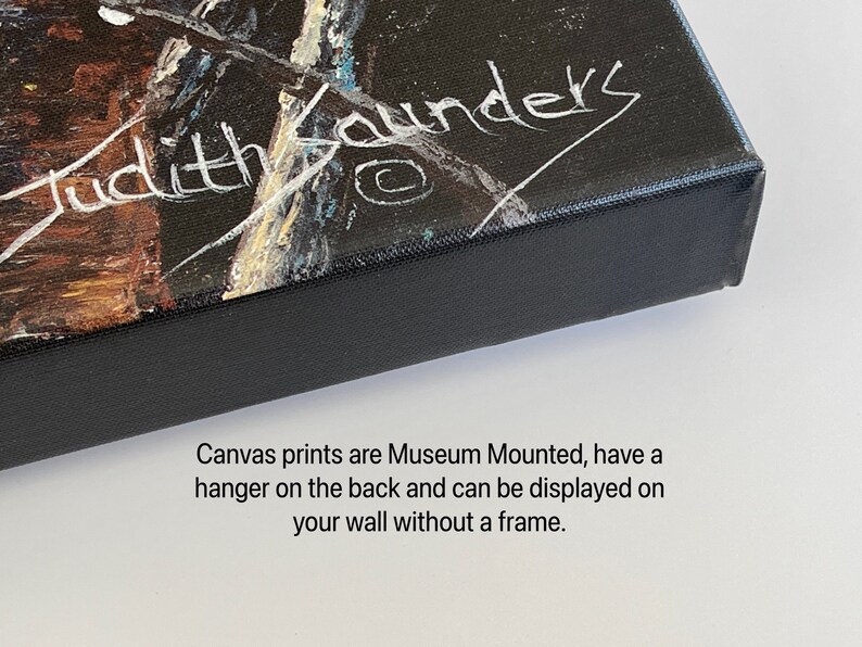 May include: Close-up of the edge of a canvas print with a black frame. The print has a white signature that reads "Judith Saunders". The text below the signature reads "Canvas prints are Museum Mounted, have a hanger on the back and can be displayed on your wall without a frame."
