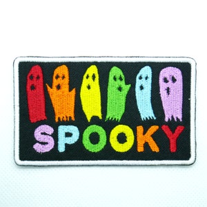May include: A black embroidered patch with a row of rainbow colored ghosts and the word "SPOOKY" in rainbow colors.