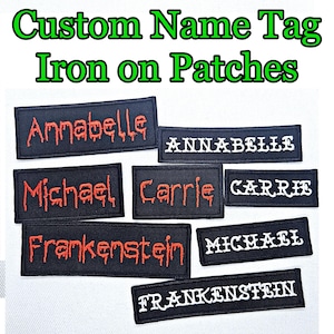 May include: A set of eight iron-on patches with various names, including Annabelle, Michael, Carrie, and Frankenstein. The patches are black with red or white lettering.