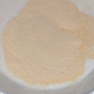 Puede incluir: Primer plano de un mont&oacute;n de polvo beige claro en un plato de papel blanco.