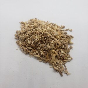 Pu&ograve; includere: Un mucchio di pezzi di radice secchi, di colore marrone chiaro e beige, su una superficie bianca. I pezzi di radice hanno una forma irregolare e una consistenza ruvida.