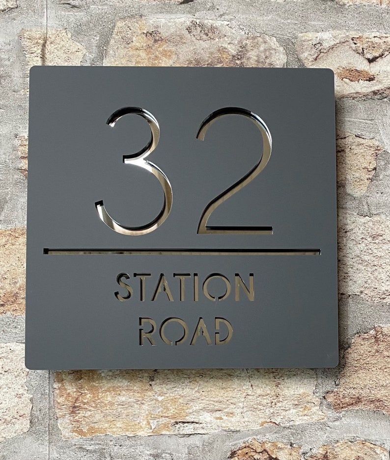 Puede incluir: Un letrero de n&uacute;mero de casa cuadrado negro con el n&uacute;mero 32 y el texto "STATION ROAD" en blanco.