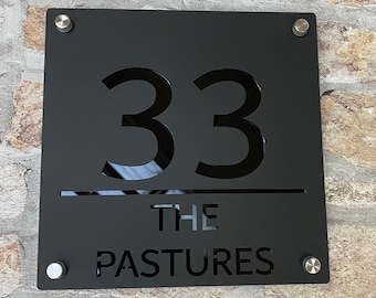May include: Black metal house number sign with the number 33, the words "THE PASTURES" and four silver screws.