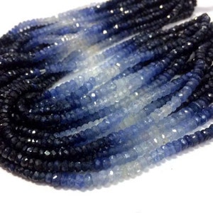 Op de afbeelding: Een streng blauwe saffier kralen, die in kleur aflopen van donkerblauw naar lichtblauw, met een paar doorlopende heldere kralen.
