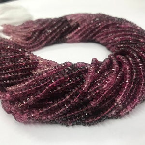 May include: A strand of pink and purple gemstone beads. The beads are faceted and have a slightly irregular shape. The strand is coiled and ready to be used for jewelry making.