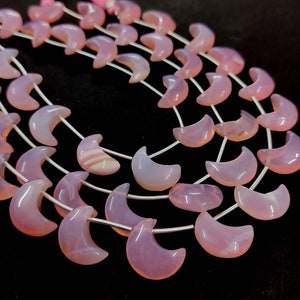Peut inclure: Un brin de perles de calcédoine rose en forme de croissant de lune. Les perles sont enfilées sur un fil d'argent.