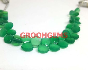 Puede incluir: Una hebra de cuentas de piedras preciosas verdes, cada cuenta es de forma ovalada facetada. Las cuentas están enhebradas en un alambre de plata.