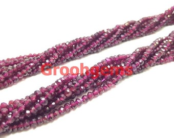 May include: A strand of deep red garnet beads, faceted and strung together. The beads are small and uniform in size, creating a smooth and elegant look.