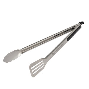 Könnte beinhalten: Grillzange aus Edelstahl mit Spatelende. Die Zange hat einen schwarzen Griff und der Text "Papa grill am besten!" ist auf das Spatelende graviert. Für das Grillen konzipiert.